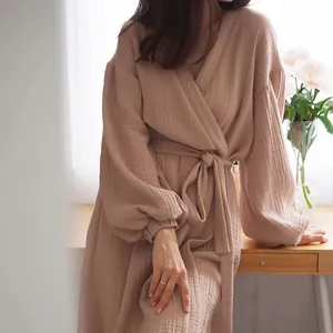 Detail view of a dusty rose cotton gauze wrap dress with elegant pleated long sleeves.