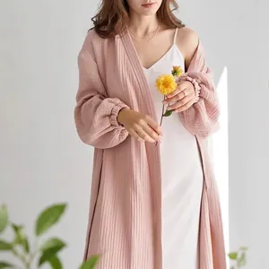 Close-up detail of soft pink crinkled gauze robe layered over white slip dress with flowers