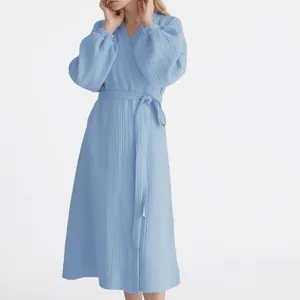 Elegant light blue smocked long sleeve wrap dress featuring a tie waist and puff sleeves