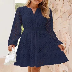 Dettaglio dell'abito blu navy con scollo a V, ricamo a occhielli e maniche lunghe.