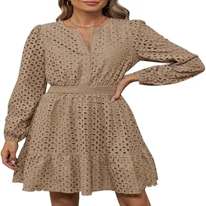 Dettaglio dell'abito in cotone beige con scollo a V e intricati ricami traforati femminili