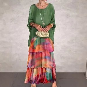 Elegant women's two-piece set featuring a green loose blouse and colorful tiered maxi skirt.