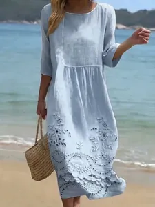 Detail of light blue midi dress with white floral embroidery and eyelet trim details