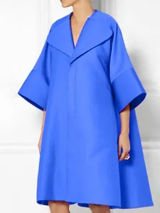 Dettaglio dell'abito oversize blu vibrante con maniche svasate e risvolto
