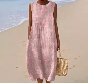Detail of a sleeveless pink floral print long dress captured at a beach setting