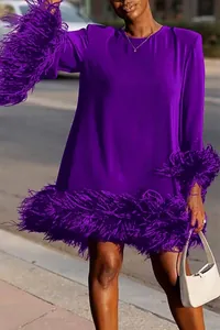 Detailansicht des leuchtend violetten lockeren Kleides mit elegantem Federbesatz