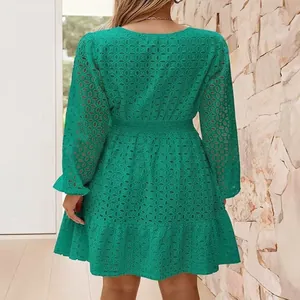 Dettaglio posteriore di un abito in cotone verde con ricamo e maniche lunghe.