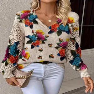 Detail of V-neck knit sweater featuring colorful floral embroidery and hollow sleeves