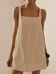 Dettaglio delle grandi tasche anteriori su un abito a gilet beige senza maniche
