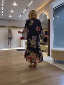 Elegante vestido largo con estampado floral, mangas campana tres cuartos y caída fluida.