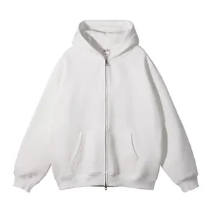 Detail van een witte oversized zip-up hoodie met kangoeroezak en geribde manchetten.