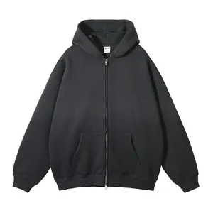 Detail van een zwarte oversized hoodie met ritssluiting, capuchon en voorzakken.