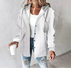 Close-up of white cable-knit hooded jacket with grey pocket and buttons