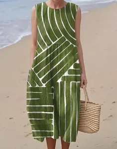 Close-up of sleeveless green maxi dress with white geometric pattern on beach
