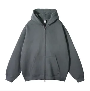 Close-up van een effen donkergrijze oversized hoodie met rits en kangoeroezak aan voorzijde