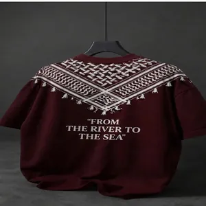 Oversized maroon drop-shoulder T-shirt featuring geometric patterns and printed slogan.