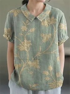 Detail of vintage floral embroidery on sage green linen blouse with Peter Pan collar