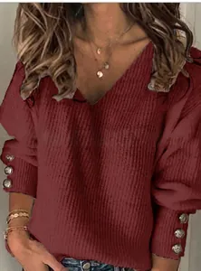 Dettaglio del maglione bordeaux con scollo a V e polsini decorati con bottoni eleganti