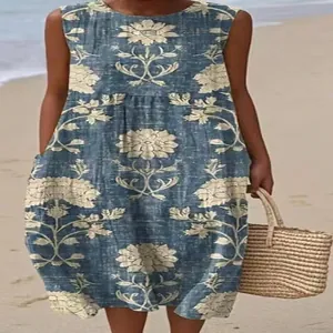 Close-up view of a sleeveless blue floral midi dress with tan flower patterns on the beach