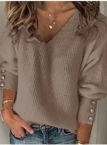 Primo piano di un maglione in maglia taupe da donna con scollo a V e dettagli sui polsini.