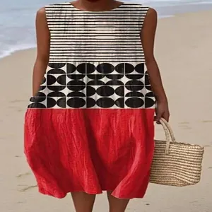 Casual sleeveless maxi dress with black stripes and geometric print over a red skirt on beach