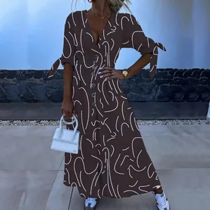 Elegante bruine maxi-jurk met witte abstracte lijnenprint en V-hals met knoopsluiting