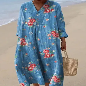 Loose-fit blue floral V-neck maxi dress with long sleeves in a casual beach setting