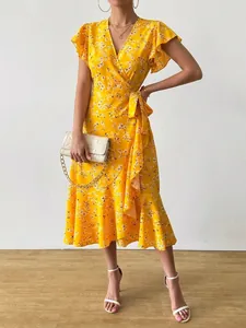 Close-up of yellow floral wrap dress with ruffled hem and butterfly sleeves
