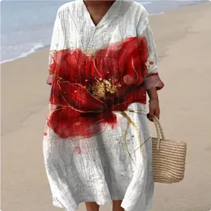 Close-up detail of a loose V-neck long sleeve floral print maxi dress styled on a sunny beach