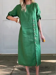 Vestido midi de lino verde con cuello redondo y botones decorativos laterales.