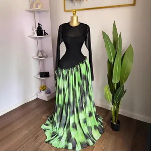 Robe élégante à manches longues avec haut en tulle noir et jupe longue imprimée verte.