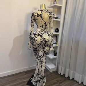 Vista detallada de vestido largo de malla con flores flocadas negras y fruncidos