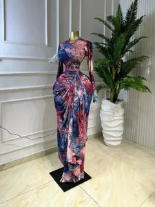 Full length view of elegant abstract floral printed long sleeve ruched maxi dress on mannequin.