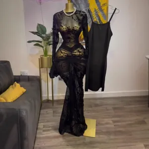 Elegante vestido de malla negra de manga larga con flocado floral y vestido interior