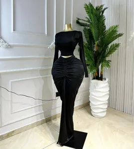 Elegant black two-piece set featuring long-sleeved crop top and ruched maxi skirt