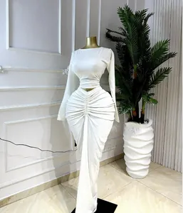 Elegant white two-piece set featuring a long sleeve crop top and ruched maxi skirt