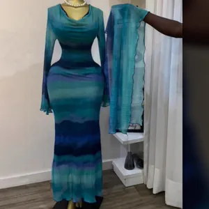 Elegante abito lungo tie-dye blu a maniche lunghe con sciarpa coordinata su un manichino.