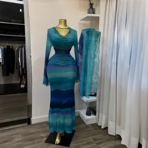 Elegante abito lungo blu tie-dye con sciarpa coordinata su manichino dorato da boutique