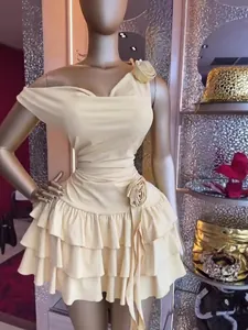 Elegante abito corto monospalla crema con fiori 3D e balze a strati.