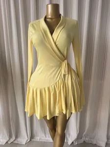 Dettaglio di un elegante abito a portafoglio giallo a maniche lunghe con bordo a pieghe
