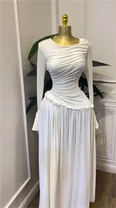 Elegante vestido largo plisado de manga larga blanco con detalle de volantes en la cintura.