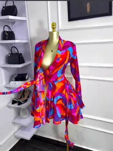 Dettaglio di un vestito a portafoglio con stampa astratta vivace e gonna a pieghe