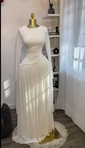Vestido largo blanco de manga larga con pliegues y detalle de volante en cintura