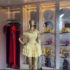 Dettaglio di un abito corto giallo a spalle scoperte con fiori 3D e gonna a balze molto raffinata