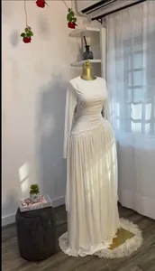 Elegante vestido de noche plisado blanco de manga larga en maniquí