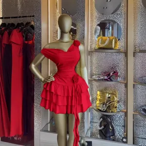 Elegante abito corto rosso senza maniche con volant e decoro floreale su un manichino