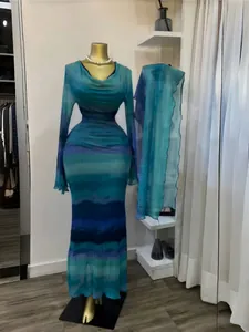 Dettaglio dell'abito lungo con stampa tie-dye, maniche lunghe e sciarpa coordinata.