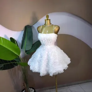 Detailweergave van een witte jurk met bandjes en een getextureerde bloemenrok