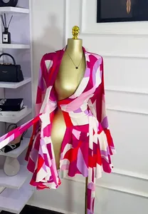 Abito a portafoglio rosa con stampa geometrica, maniche lunghe e gonna a pieghe su manichino.