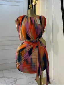 Vibrant tie-dye sleeveless top and pleated mini skirt two-piece set on mannequin.